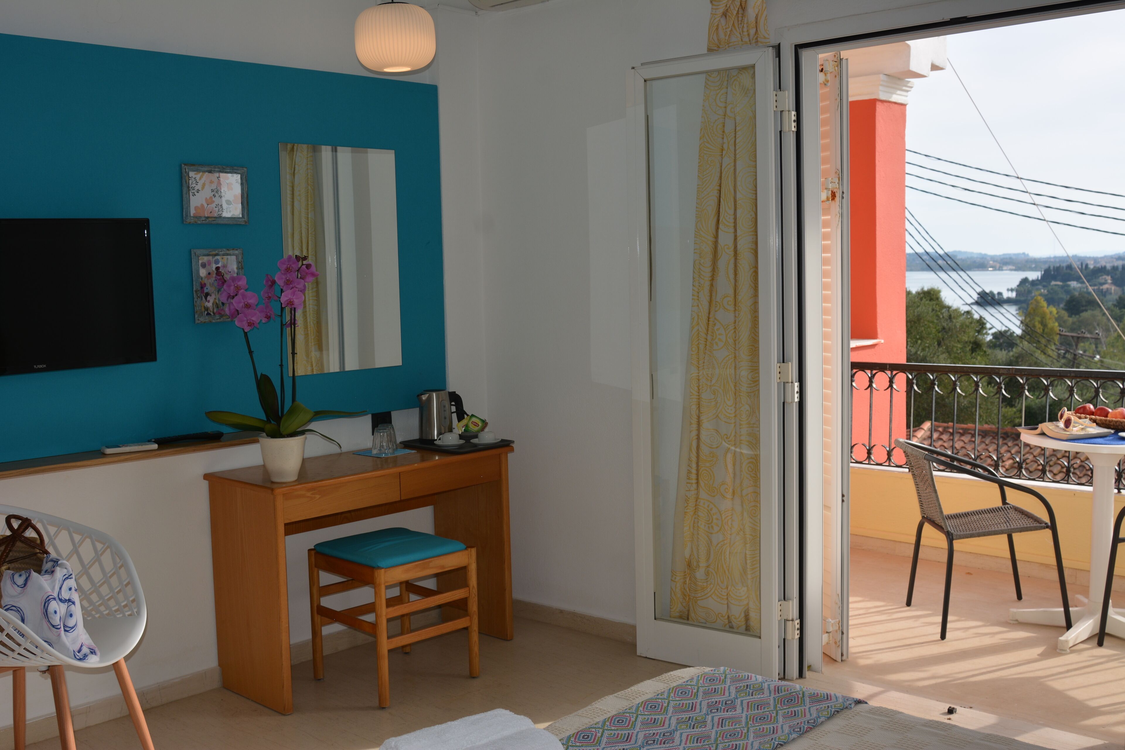 Una stanza con scrivania, sedia e vista su un balcone con mobili da esterno.