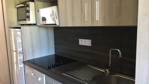 A modern kitchen with a black countertop, stainless steel sink, and wooden cabinets. - 2 rooms St Raphaël from Saturday 12/08 > 19/08/2023: €795 per week (Saint-Raphaël)