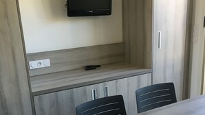 A modern kitchen with a built-in TV, wooden cabinets, and a dining area with a table and chairs. - 2 rooms St Raphaël from Saturday 12/08 > 19/08/2023: €795 per week (Saint-Raphaël)