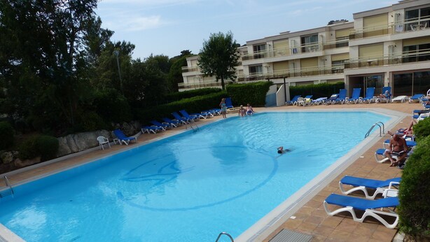 A swimming pool with blue water, surrounded by lounge chairs and a building in the background. - 2 rooms St Raphaël from Saturday 12/08 > 19/08/2023: €795 per week (Saint-Raphaël)