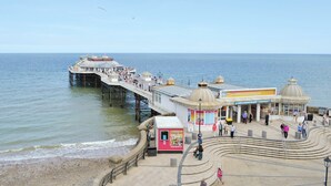 Un muelle que se adentra en el mar con un pabellón y un teatro.