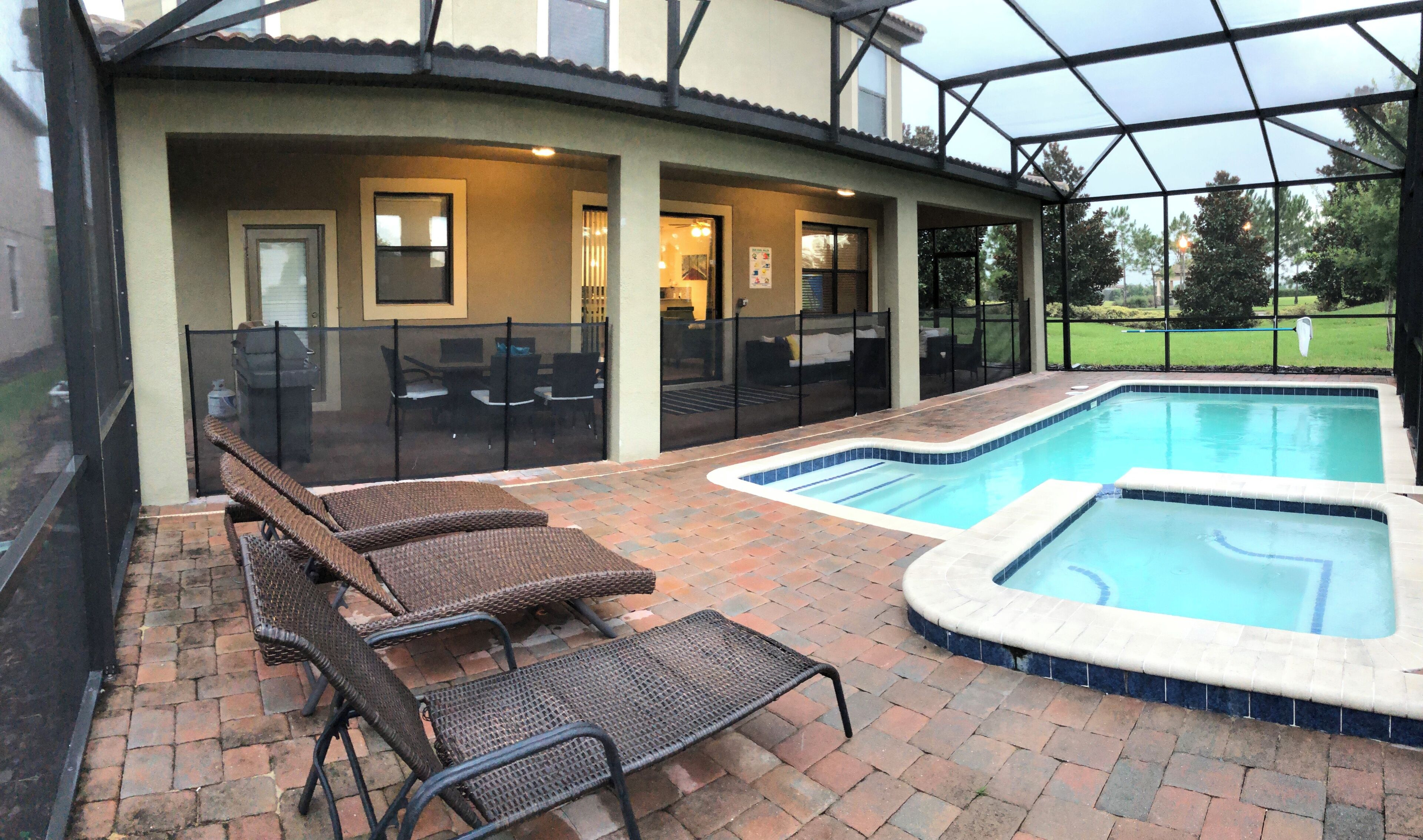A covered patio area with a swimming pool and lounge chairs.