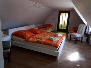 Cozy loft-style apartment with a large bed, comfortable armchair, and functional workspace.