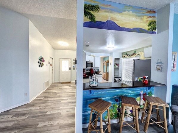 Enjoy cooking in this well-equipped kitchen with a central island and vibrant mural.