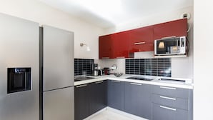 A modern kitchen with a refrigerator, microwave, and dark cabinets.