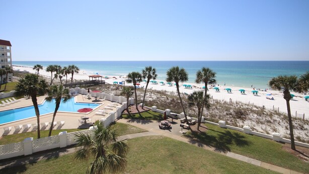 A resort with a pool, beach, and palm trees. - El Matador 447 - FREE TICKETS!! Your stay includes free tickets to many area attractions! (Fort Walton Beach)