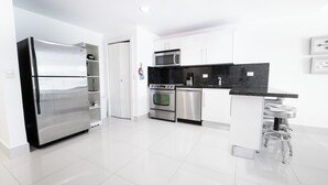 A modern kitchen with stainless steel appliances, white cabinetry, and a black countertop. - Seawinds Cabarete Beachfront Penthouse, Stunning Balcony Views, Sleeps 6 (Cabarete)