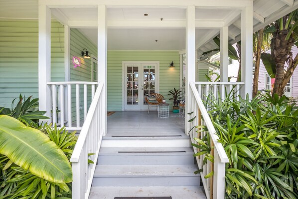 A porch with a white railing, a bench, and potted plants. - Miami River Inn By Renzzi (Miami)