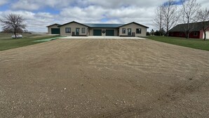 A large building with a green roof, a covered driveway, and a well-maintained lawn. - 40 Creek Lodge North at Waubay Lake (Waubay)