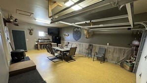 A room with a table and chairs, a door, and a wall-mounted emblem. - 40 Creek Lodge North at Waubay Lake (Waubay)