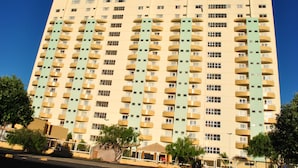 Ein mehrstöckiges Hotel mit einheitlicher Fassade, zahlreichen Balkonen und einem zentralen Eingang.