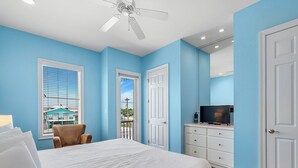 A bedroom with a bed, a chair, a TV, and a dresser.
