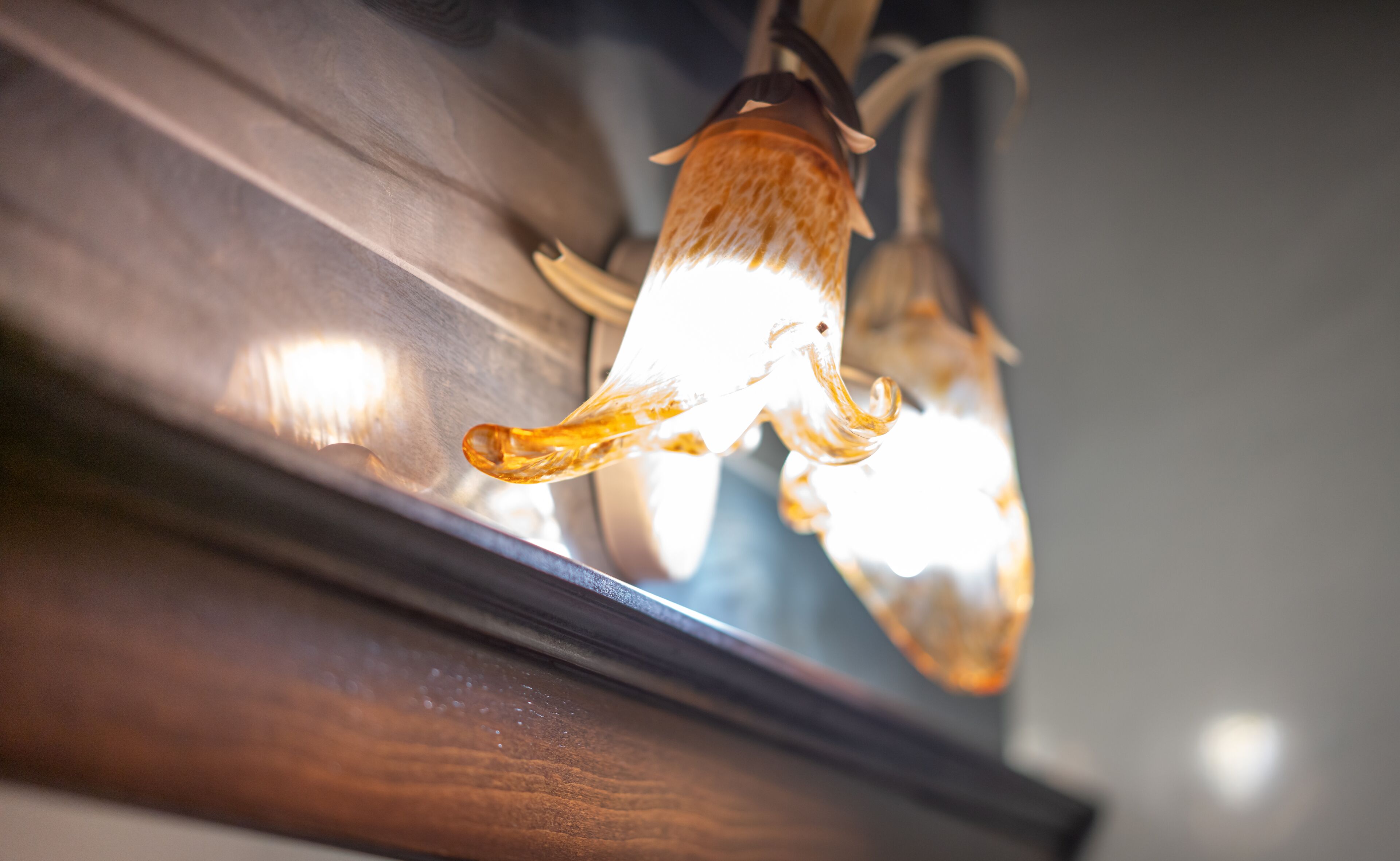 A close-up of a light fixture with a unique design, possibly made of glass or crystal, reflecting light.