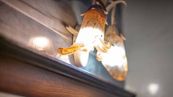 A close-up of a light fixture with a unique design, possibly made of glass or crystal, reflecting light.
