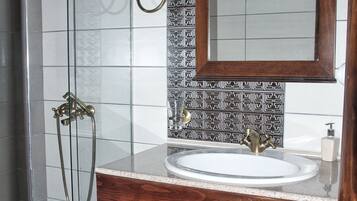 A bathroom with a glass-enclosed shower, a wooden vanity with a sink, and a mirror above it.