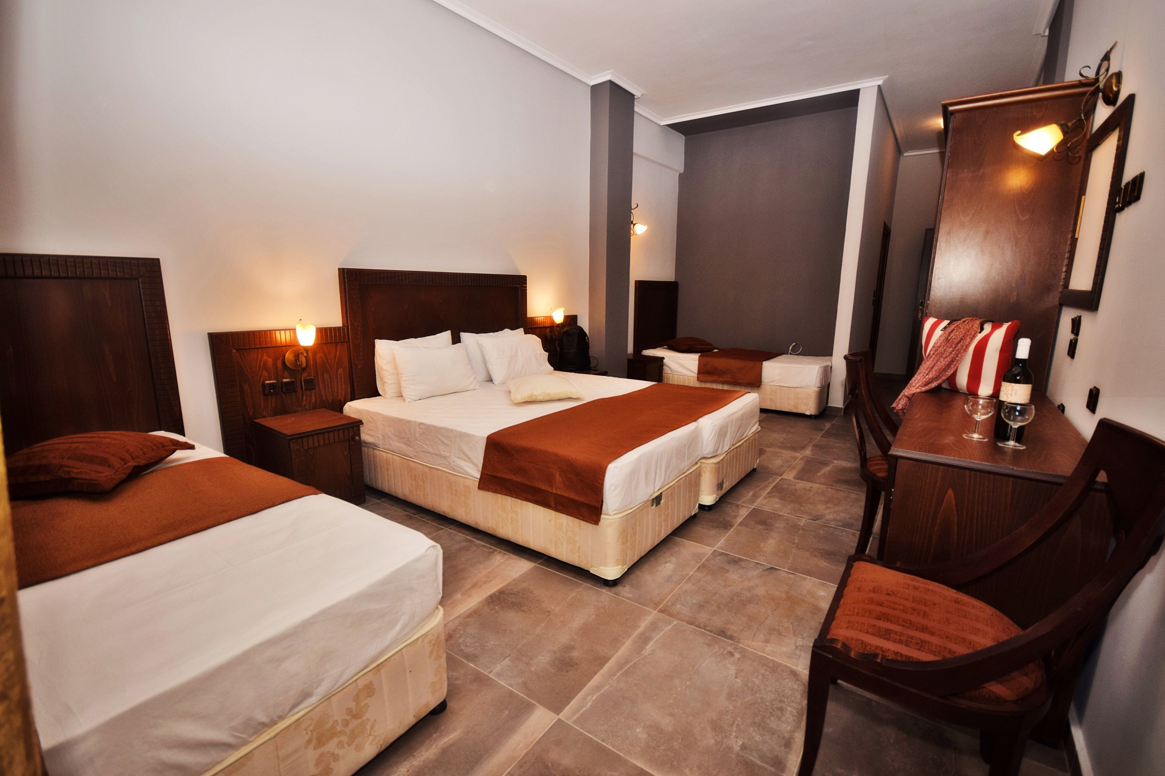 Ein Hotelzimmer mit zwei Betten, einem Schreibtisch und einem Sessel.