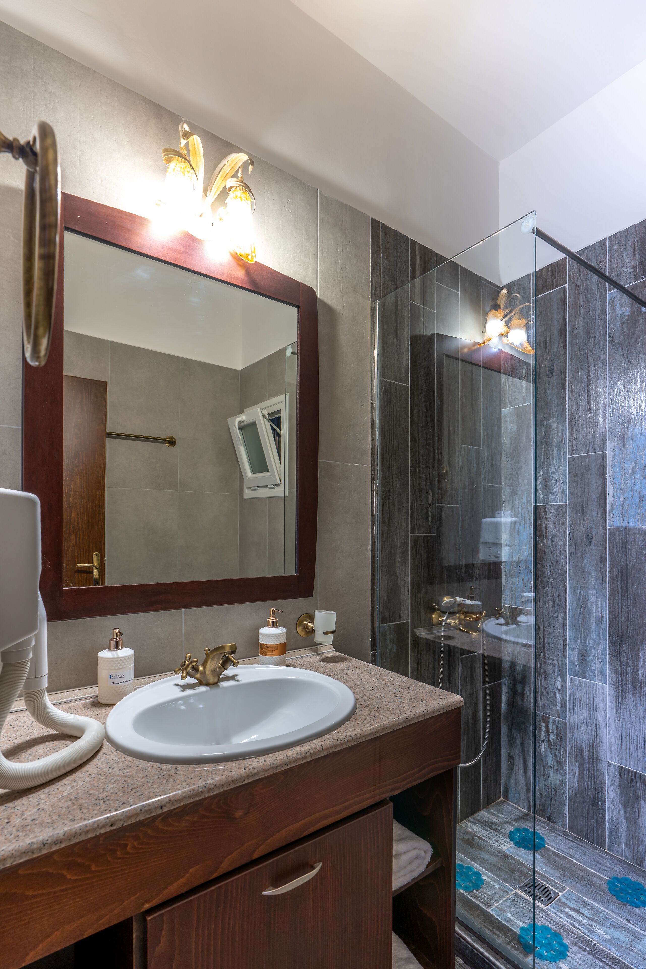 Un baño moderno con un espejo grande, un lavabo y una cabina de ducha de vidrio.