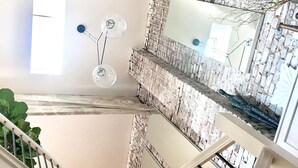 A multi-level interior with a staircase, a hanging light fixture, and a brick wall. - Luxuriously Restored Loft in Old Town Alexandria (Alexandria)
