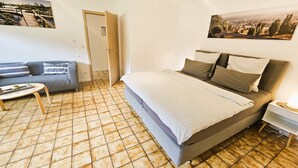 Una camera da letto con un letto, un divano, un tavolino da caffè e un quadro appeso al muro.