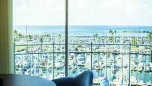 Vista de un puerto deportivo con numerosas embarcaciones amarradas, vista a través de una ventana de marco blanco.