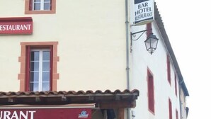 A restaurant with outdoor seating, a signboard, and a menu displayed outside. - Auberge de Saint Rome (Saint-Rome-de-Tarn)