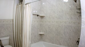 A bathroom with a toilet, a bathtub, and a shower area. - Spacious 1br Apartment in Raritan- Fully Furnished!  (Raritan)