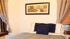 A bedroom with a large bed, a framed artwork above the bed, and curtains on the windows. - Spacious 1br Apartment in Raritan- Fully Furnished!  (Raritan)