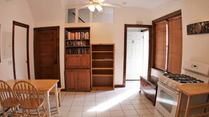 A kitchen with a dining table, chairs, a bookshelf, a stove, and a window with blinds. - Spacious 1br Apartment in Raritan- Fully Furnished!  (Raritan)