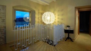 Ein Zimmer mit großem Fenster, einer dekorativen, kugelförmigen Leuchte und einem weißen Heizkörper.