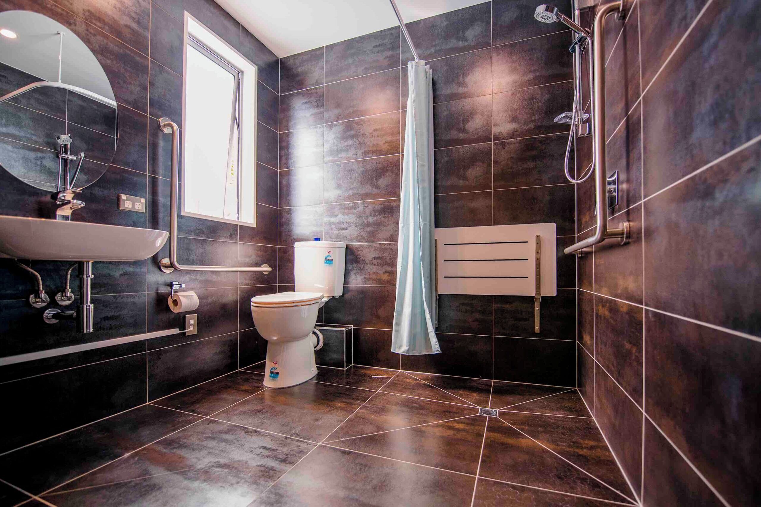 Un baño moderno con inodoro, lavamanos, ducha y toallero.