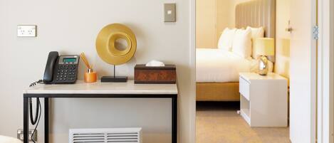 Habitación de hotel con escritorio, teléfono y objetos decorativos.