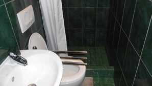 A bathroom with a white sink, a toilet, and a shower curtain. - Stone house DAN (Sveti Filip i Jakov)