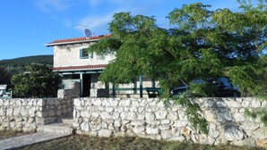 A stone-walled house with a tiled roof and a satellite dish. - Stone house DAN (Sveti Filip i Jakov)