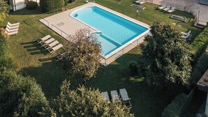 Un complexe hôtelier doté d’une piscine, de chaises longues et offrant une vue sur le paysage environnant.