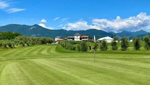 Un terrain de golf avec un club-house et des maisons en arrière-plan.