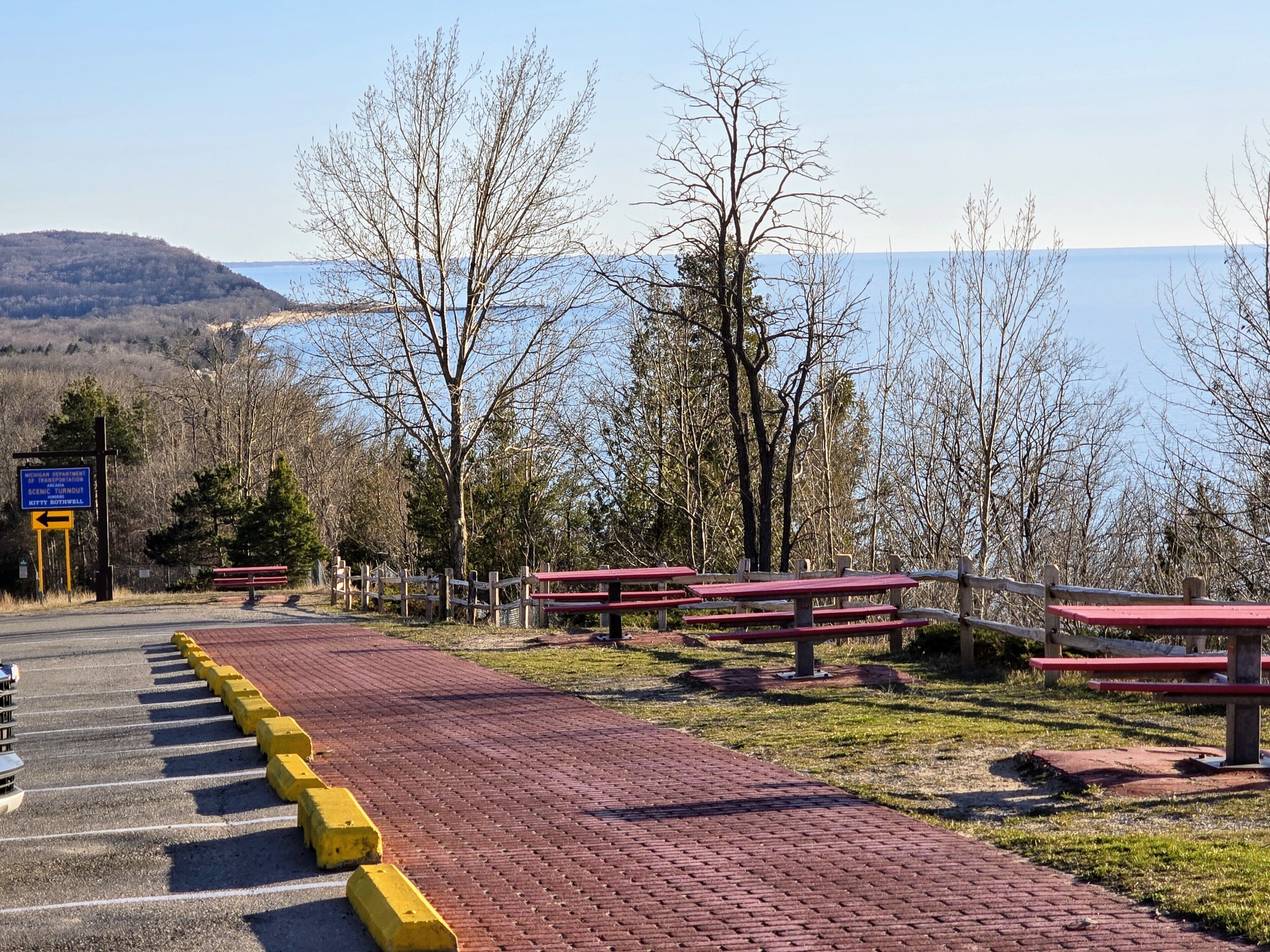 A scenic overlook with picnic tables and a sign indicating a scenic turnout.