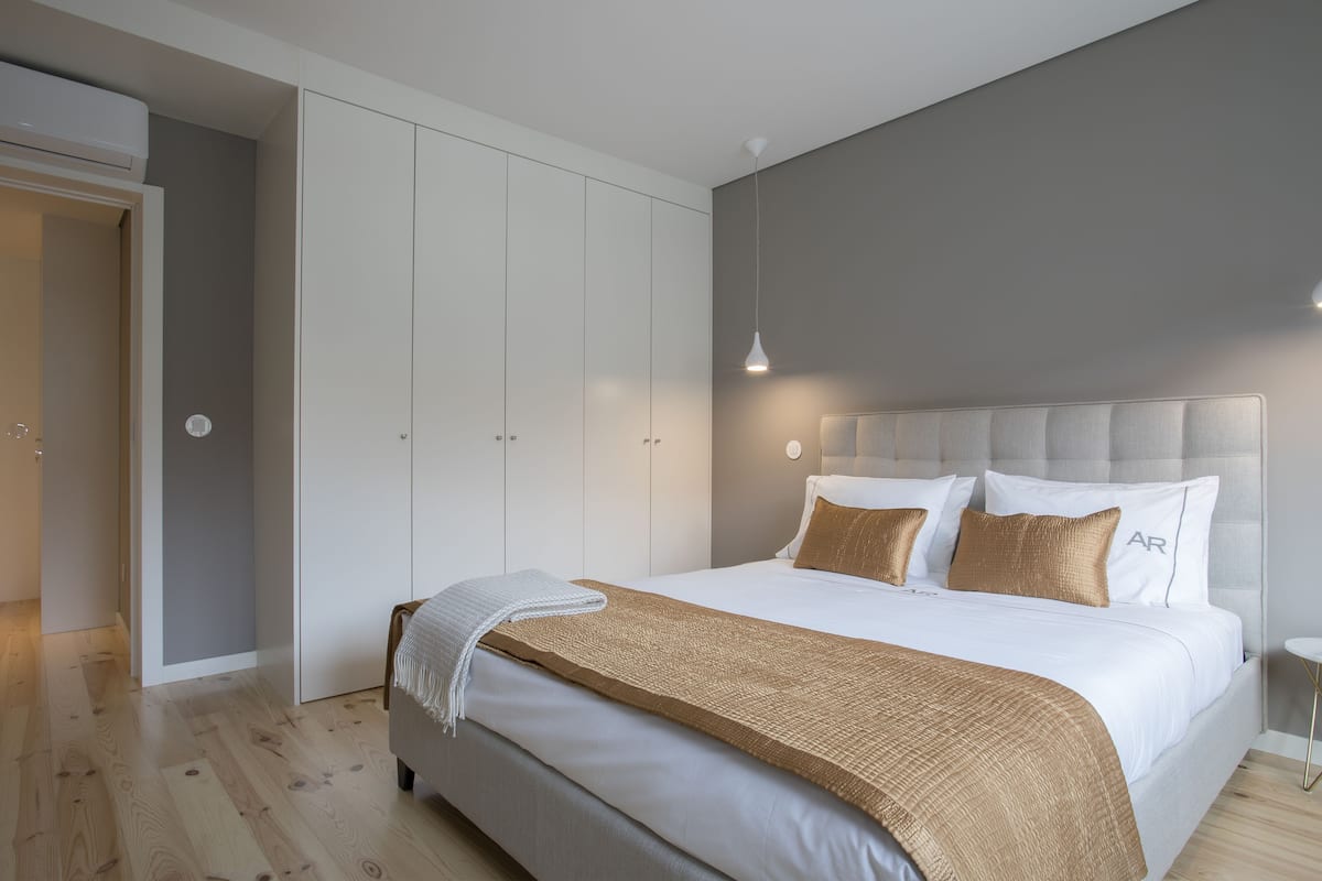Un dormitorio moderno con una cama grande, un armario y una lámpara colgante.