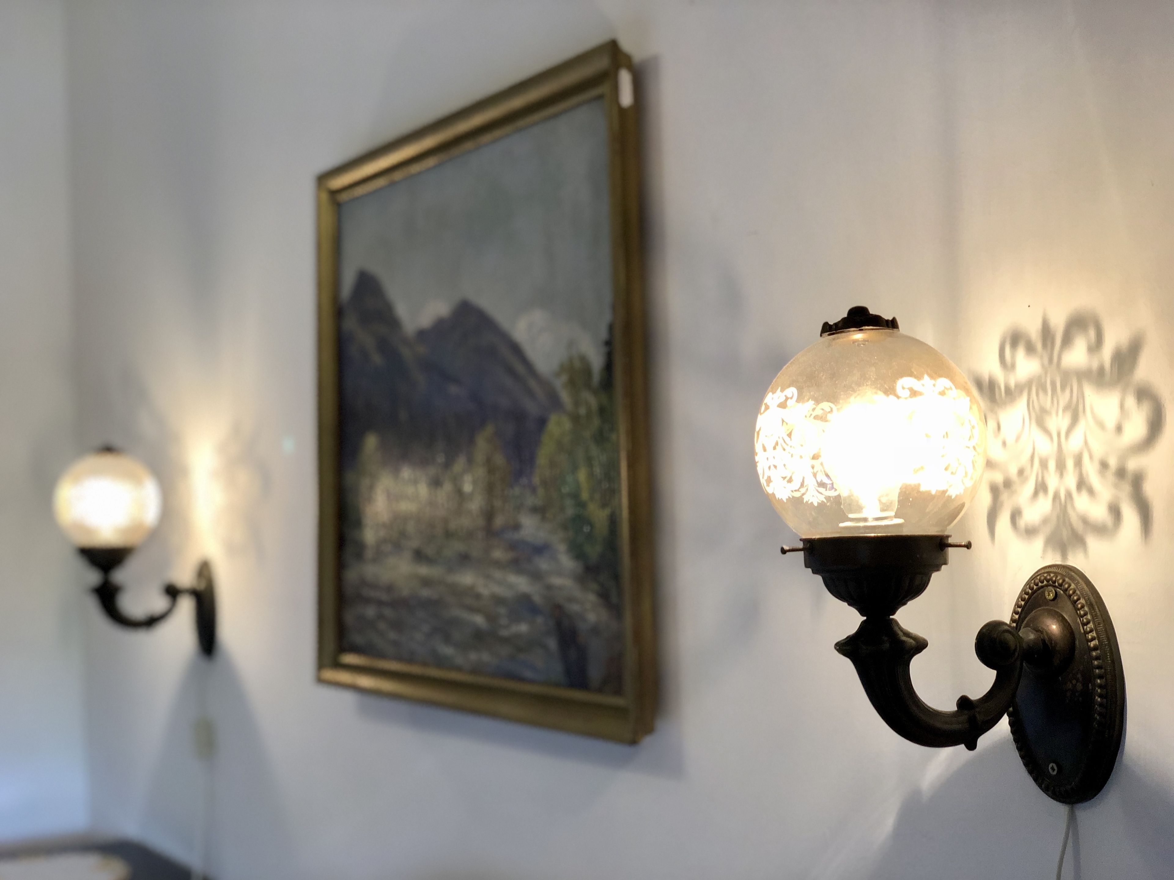 Una lámpara de pared con pantalla decorativa y un accesorio de luz instalado en la pared.