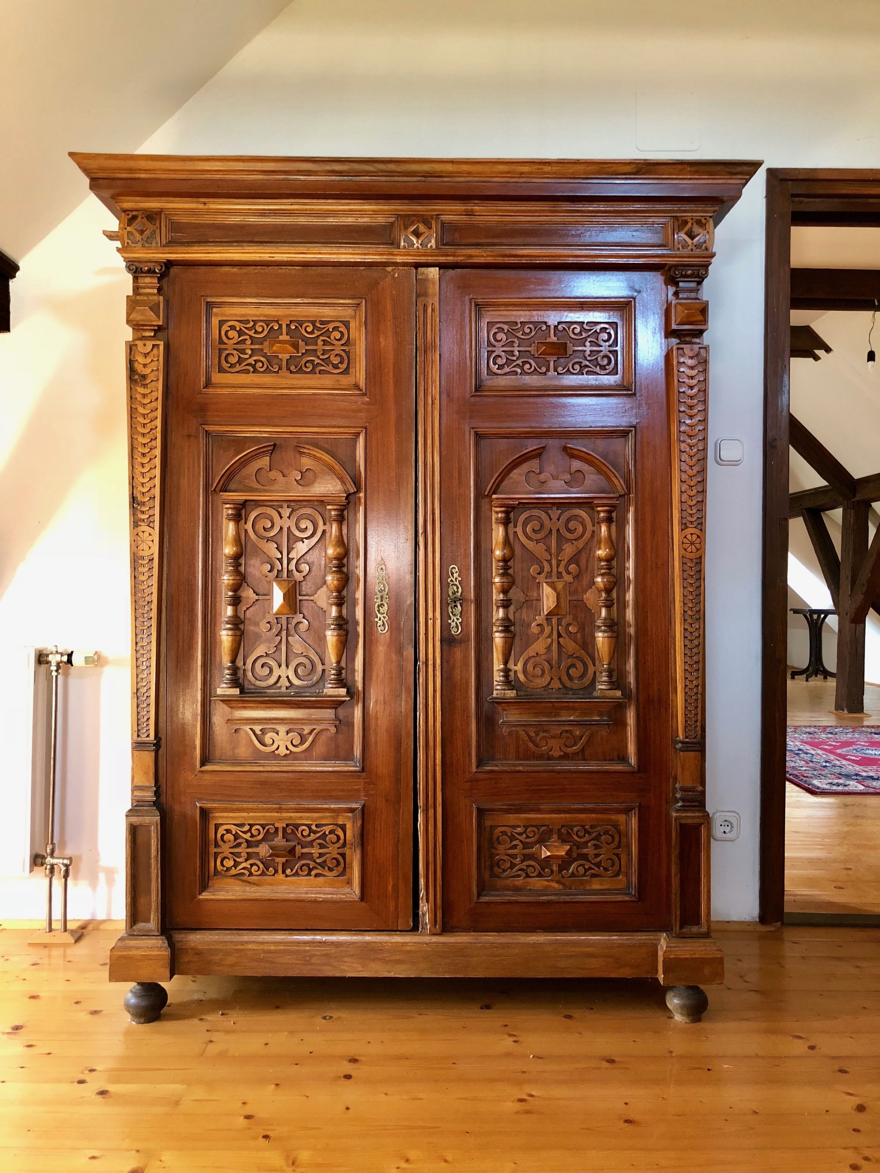 A large wooden wardrobe with intricate carvings and a classic design.