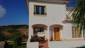 Una casa de dos pisos con un balcón, una puerta y una ventana.