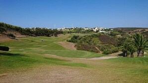 Campo de golf con vista despejada al club de campo al fondo.