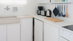 A modern kitchen with white cabinets, a sink, a coffee maker, and a Siemens oven. - Ariadne's Penthouse in Central Athens by JJ Hospitality (Athina)