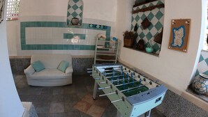 Ett rum med ett fotbollsspel, en soffa och ett fönster med utsikt.