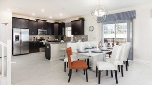 A modern kitchen with dark cabinets, stainless steel appliances, and a central island.