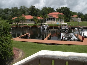 Boats docked in a serene marina surrounded by lush greenery and residential buildings.