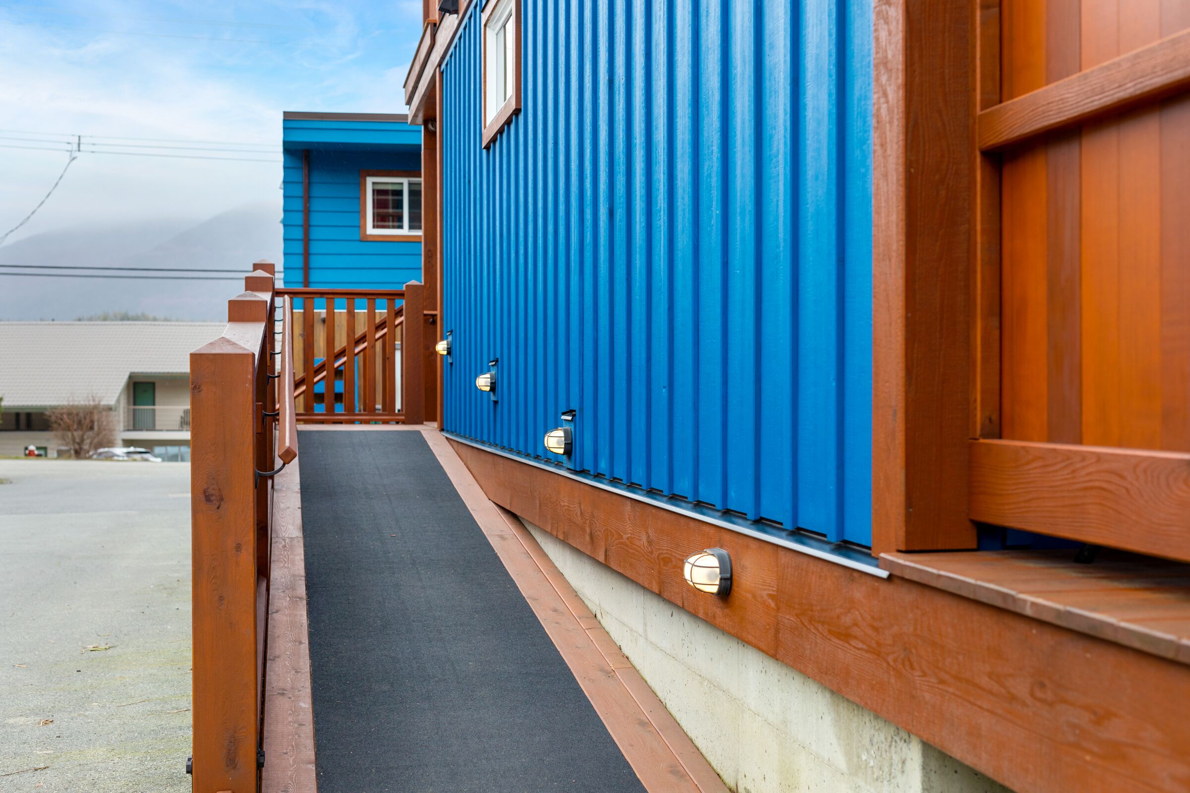 A blue building with a wooden staircase leading to a door.