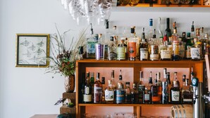 A bar area with shelves of various liquor bottles and glasses. - Pluvio Restaurant and Rooms (Ucluelet)