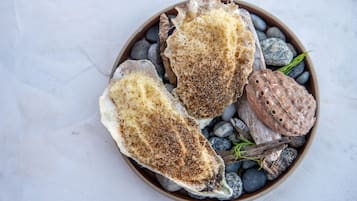 Three scallops on a bed of pebbles and seaweed.