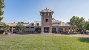 Une grande maison à étages, dotée d’une tour imposante, d’une pelouse bien entretenue et d’une allée.
