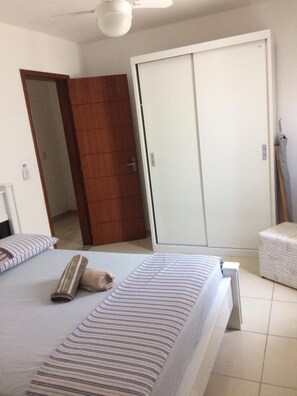 A bedroom with a bed, a wardrobe, and a ceiling fan. - Apartamentos Marina Club (Sao Pedro da Aldeia)